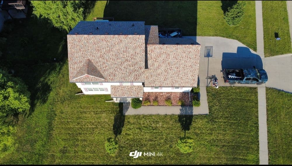 Aerial view of a suburban home with a well-maintained lawn and driveway.