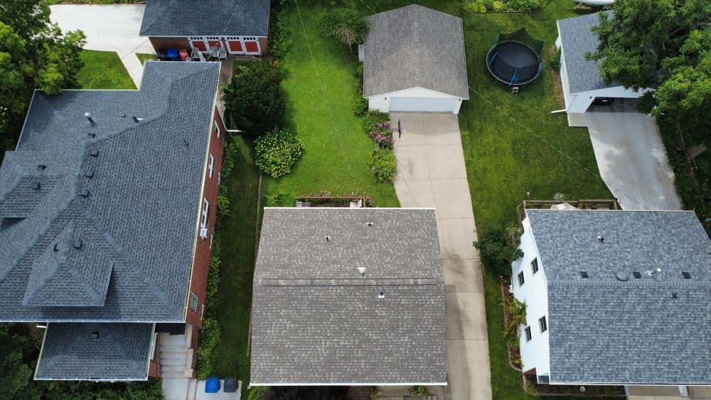 Aerial view of suburban homes with well-maintained lawns and driveway.