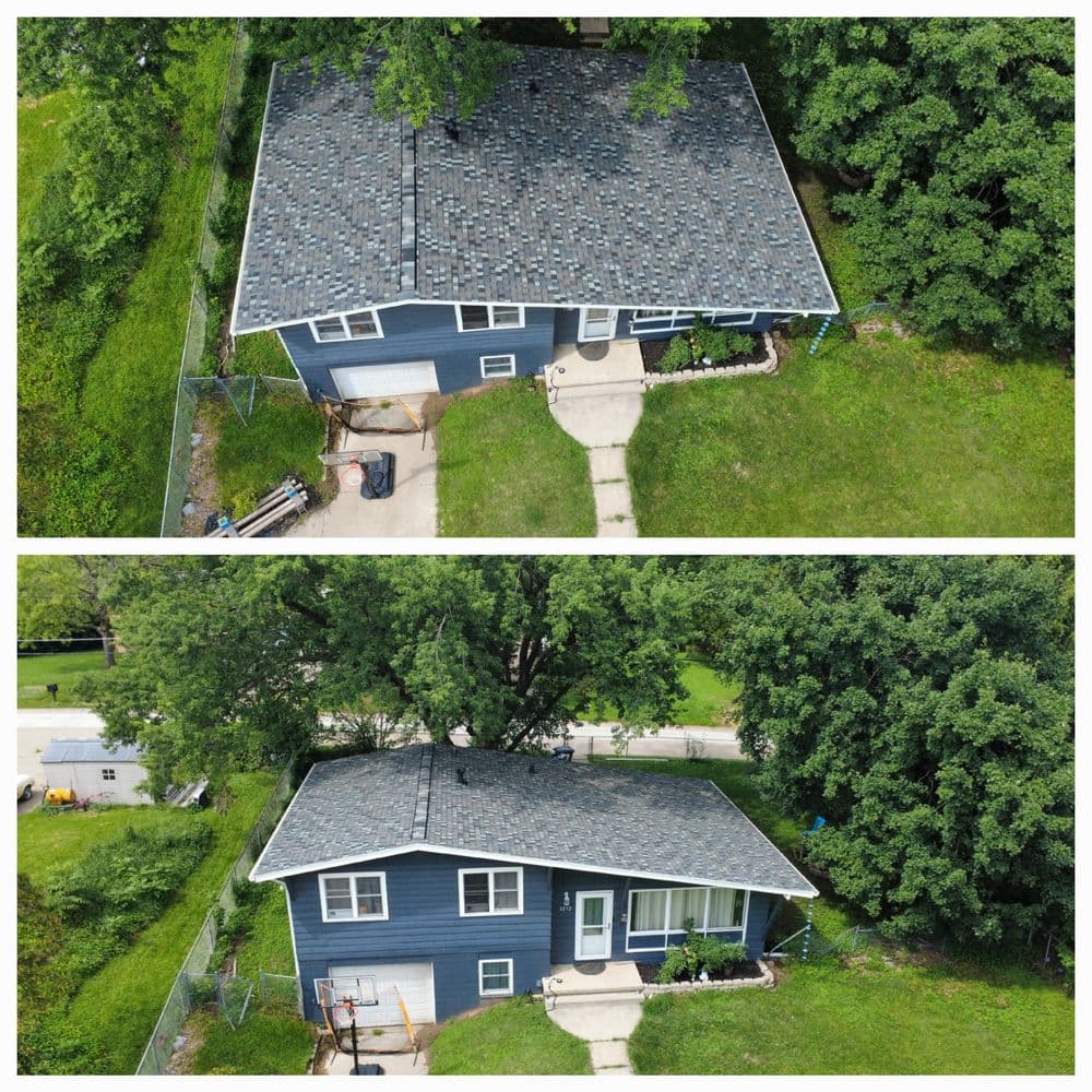 Aerial view of a blue house with a gray roof surrounded by lush greenery.
