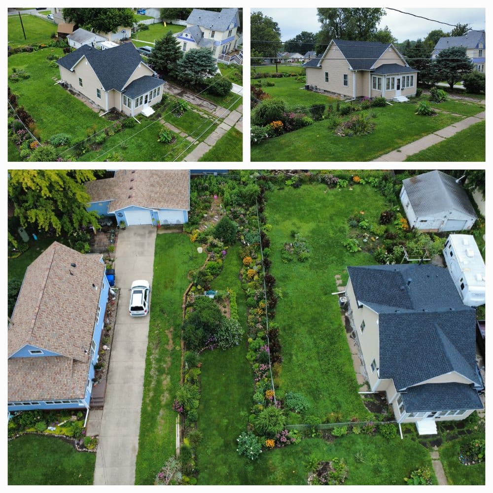 Aerial view of colorful residential properties with gardens and driveways in a suburban neighborhood.